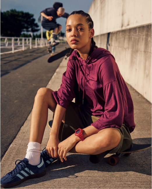 Personne en veste rouge portant une G-SHOCK à l'extérieur.