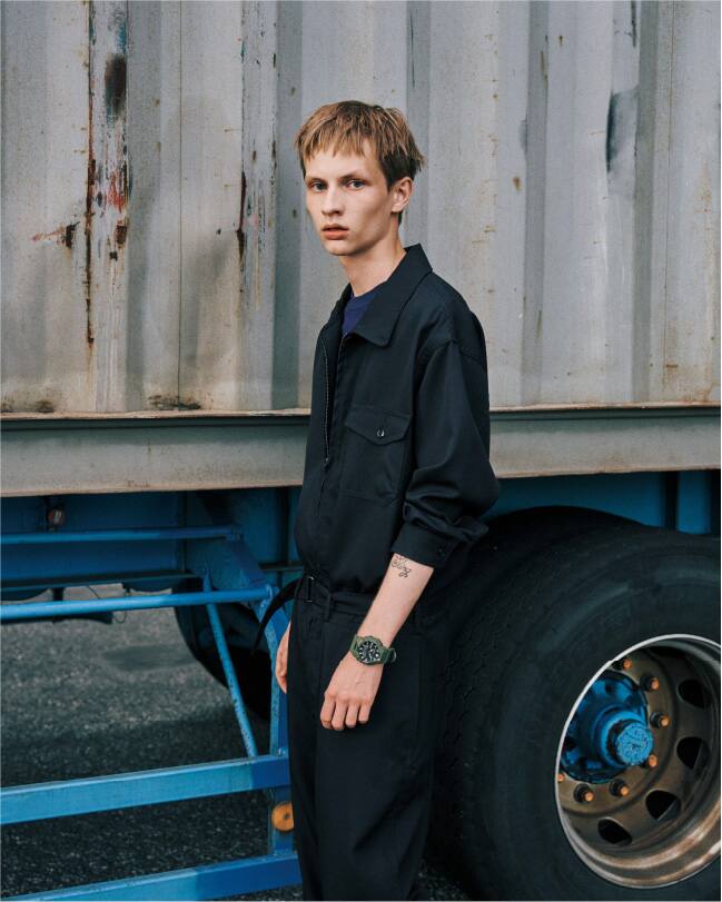 Une personne vêtue de noir se tient à côté d'un camion. Elle porte la montre G-Shock GA-B010 vert olive.