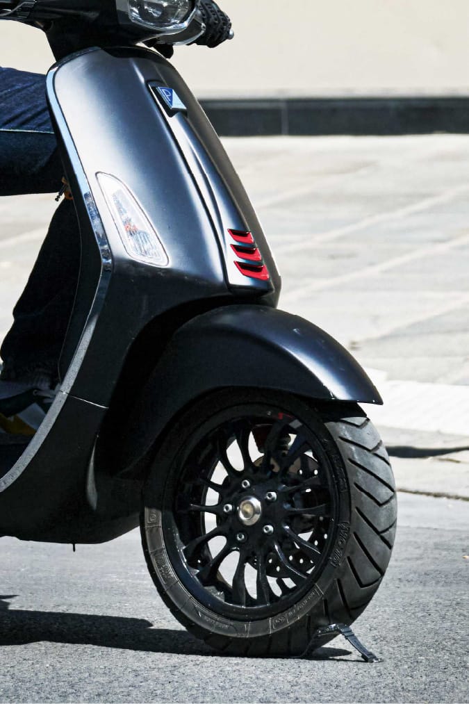 Scooter garé avec G-SHOCK au sol.