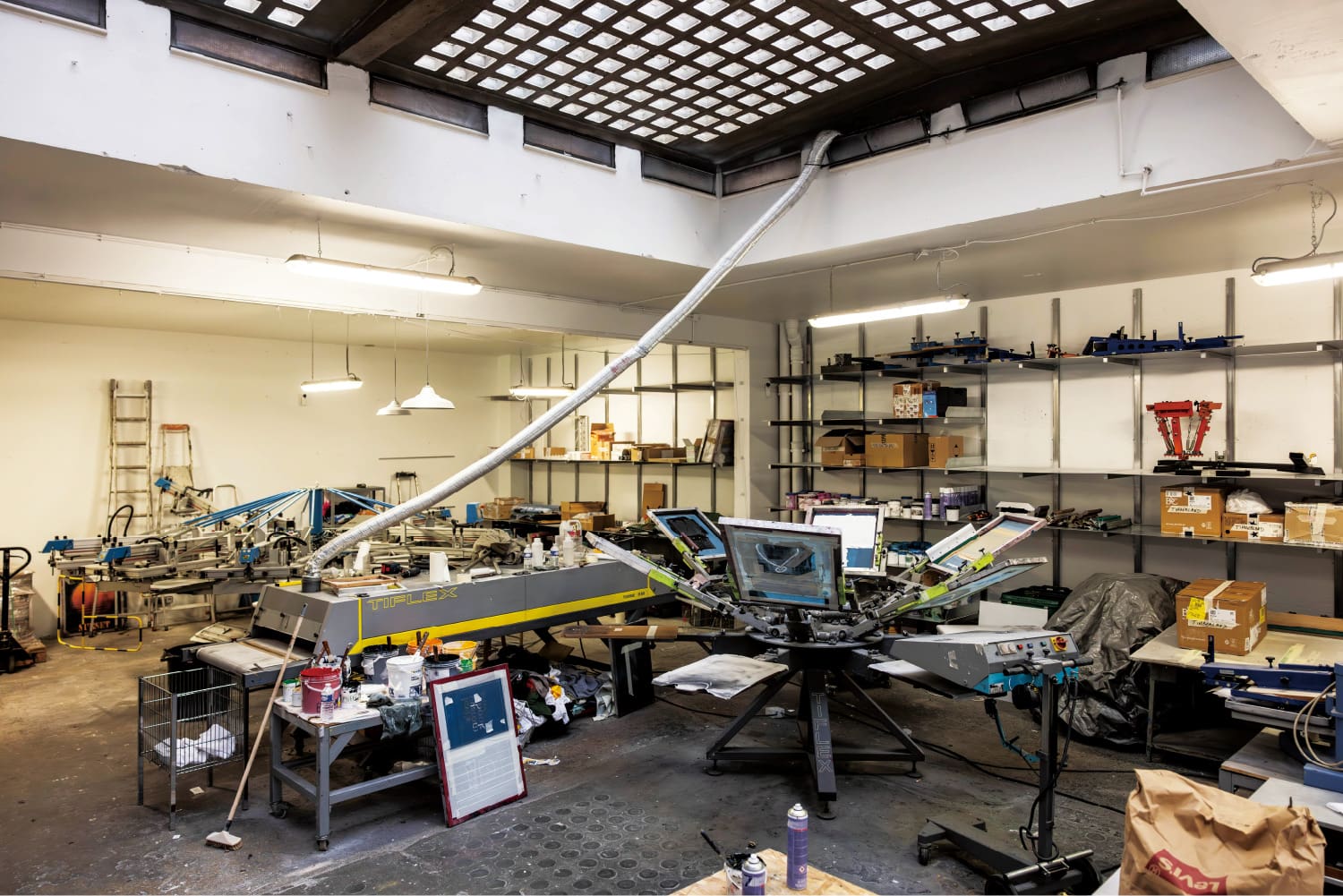 Il s'agit d'une photo d'une vue large de l'espace de travail de l'atelier de sérigraphie de Pablo Attal.