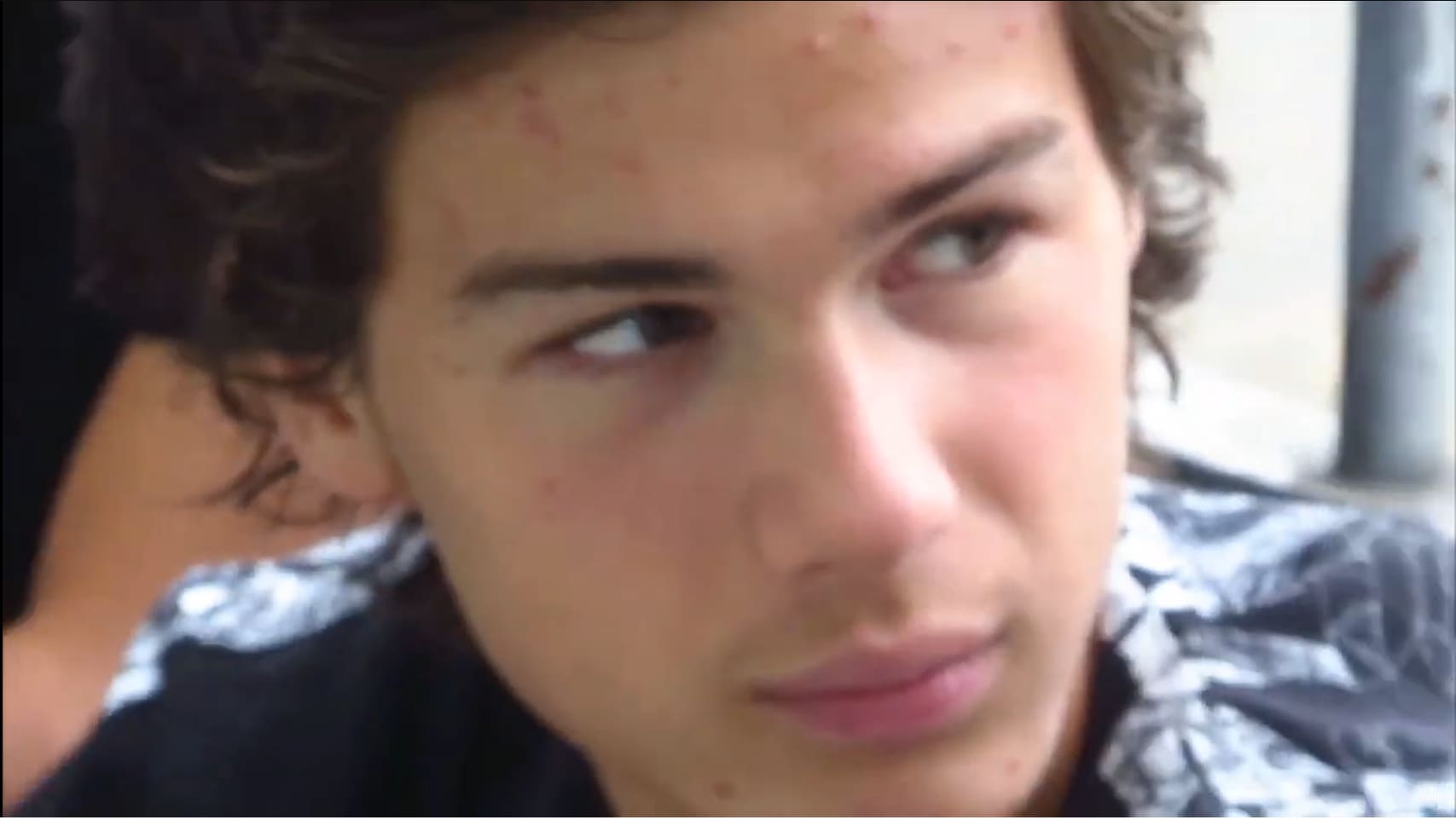 黒いキャップをかぶり、ドアの前で話すArtistic Directeur。