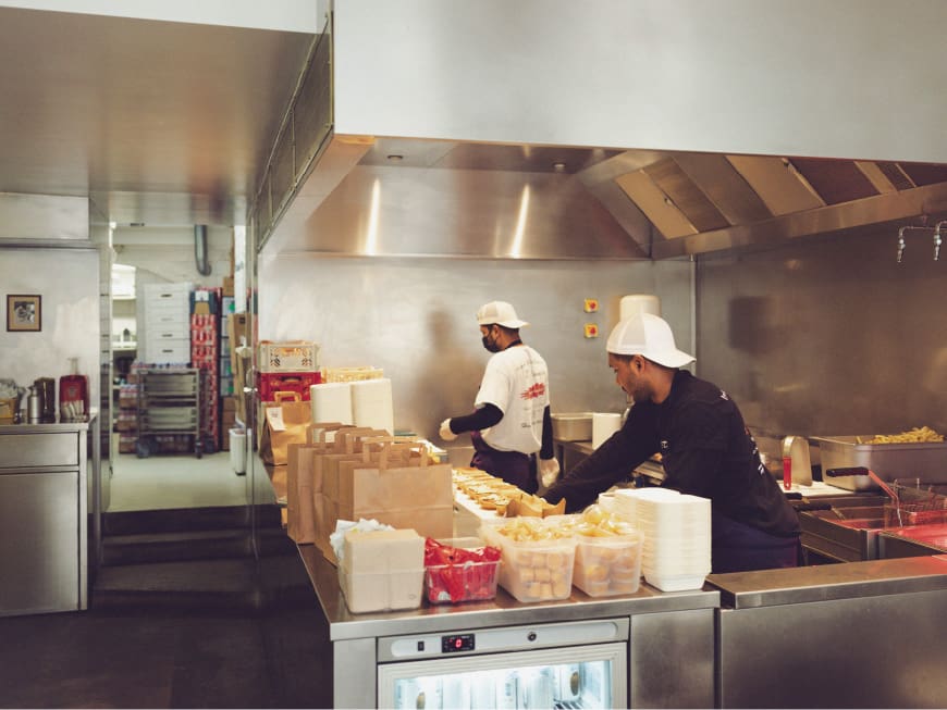 Cette photo montre des chefs préparant des smash burgers dans la cuisine du Dumbo Marais à Paris.