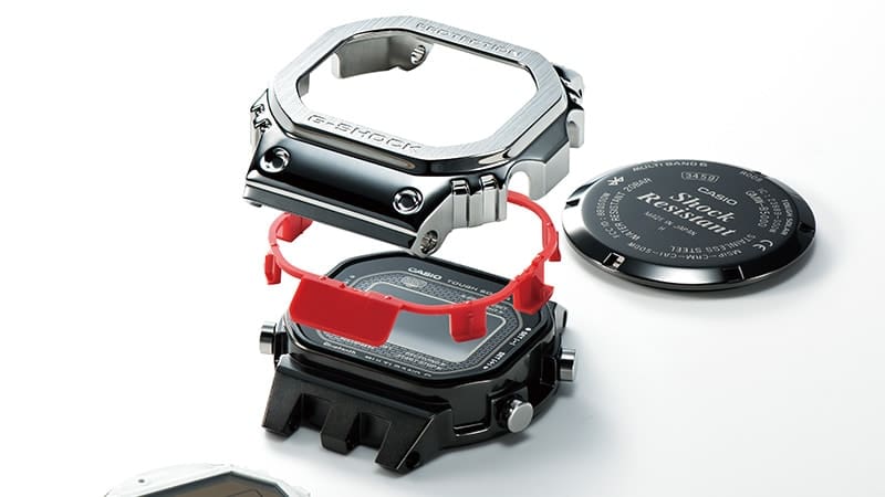 Composants du boîtier de la montre Casio G-Shock GMW-B5000 entièrement métallique présentés individuellement les uns au-dessus des autres.