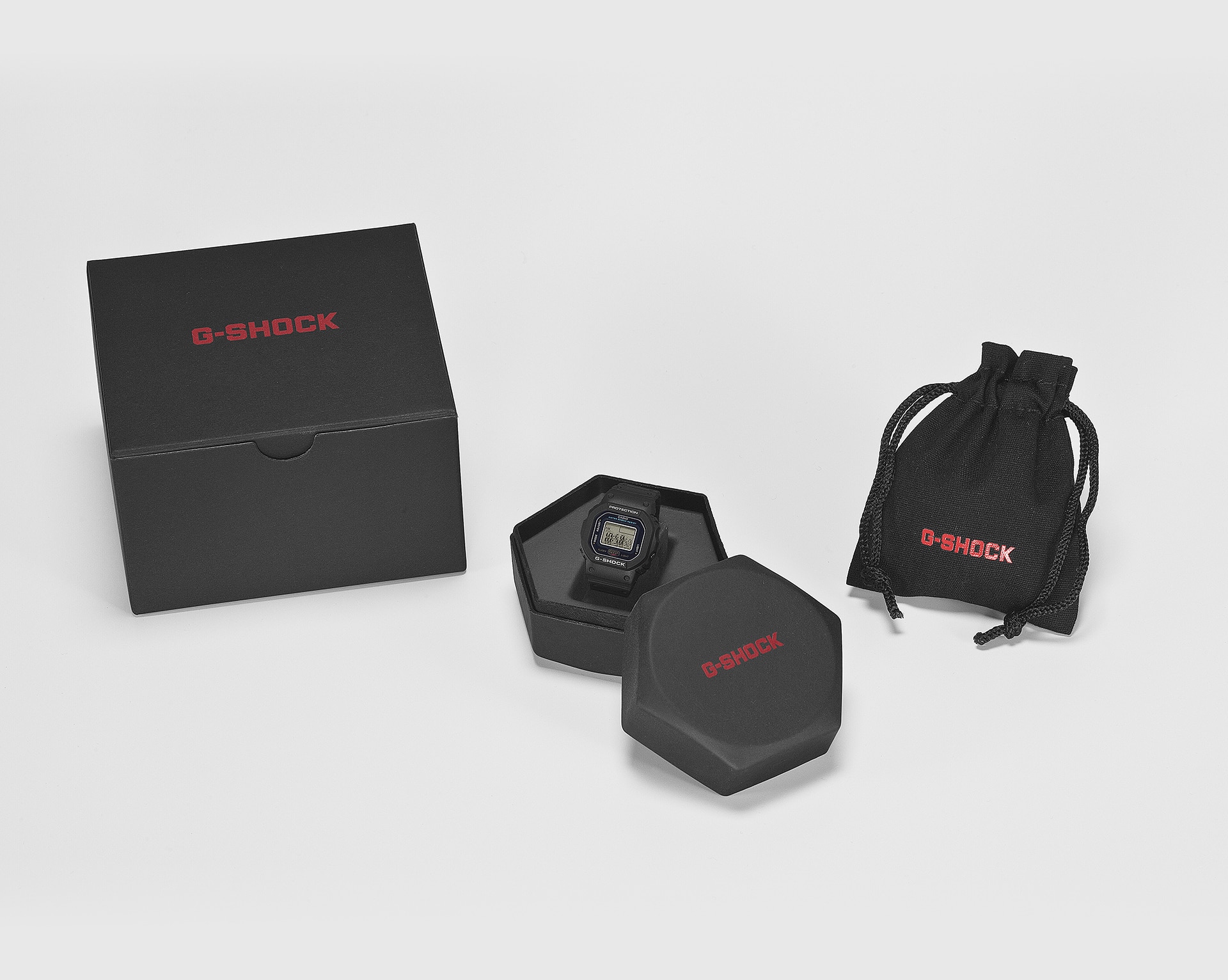 Emballage noir élégant de la montre-bague DWN-5600 avec une forme octogonale et un sac velouté supplémentaire autour.