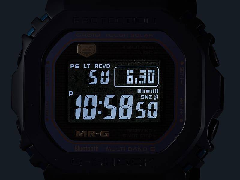 L'écran éclairé d'une montre numérique MRG-B5000BA dans l'obscurité