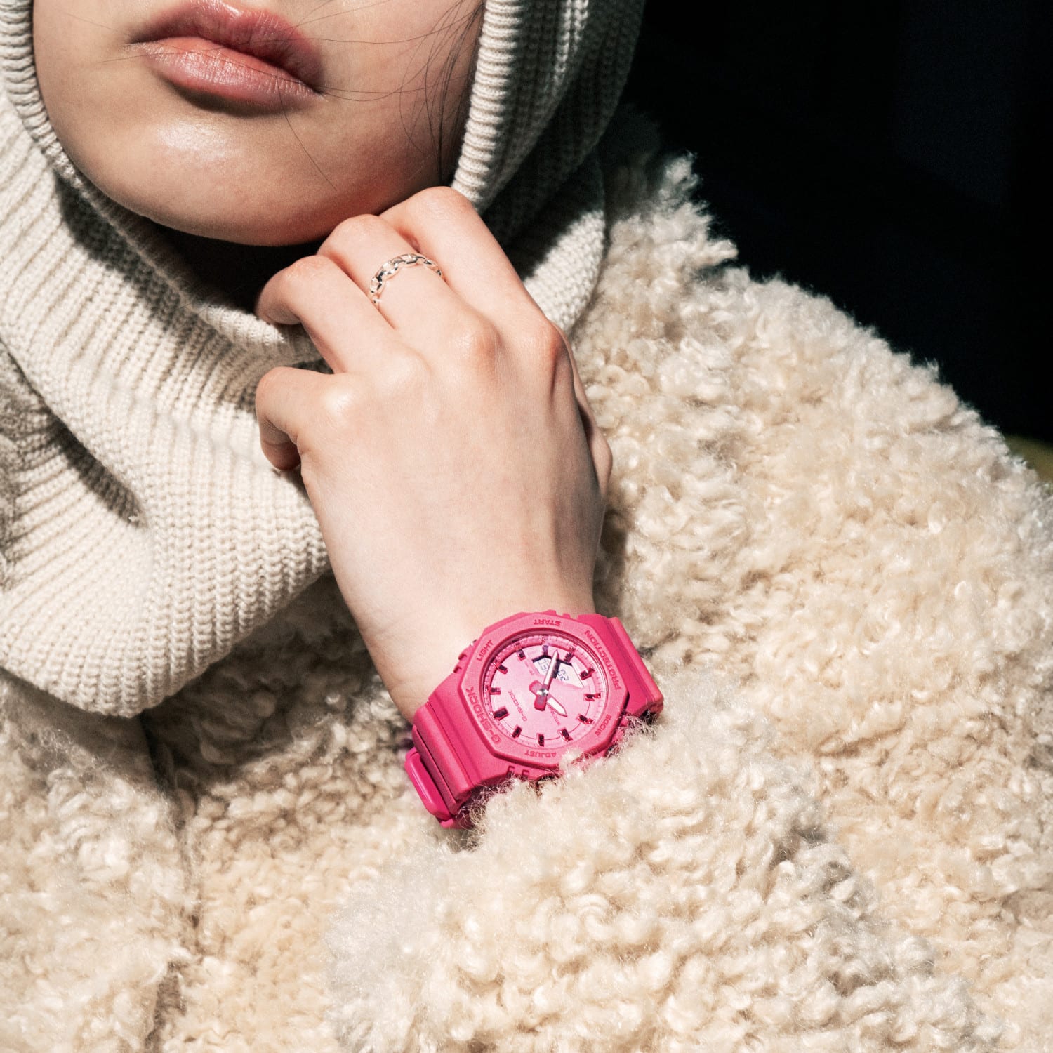 Gros plan d'une/sur une femme portant une veste et une cagoule beiges et la GMA-P2100PP-4 rose au poignet.