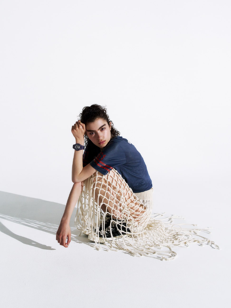 Orang yang mengenakan G-SHOCK ungu, duduk dengan rok berjaring.