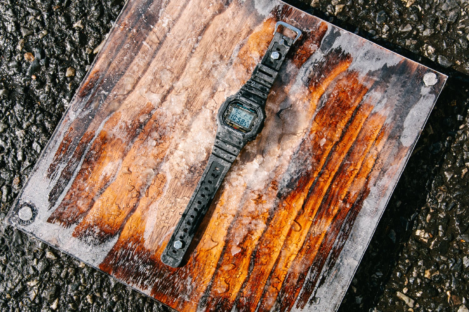 氷に覆われた風化した金属板の上にG-SHOCKが置かれています。