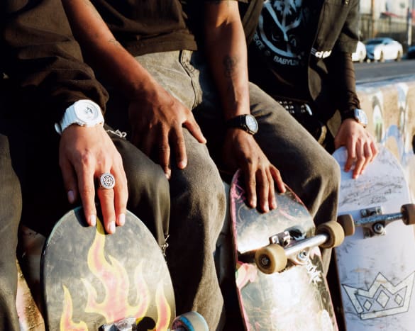 Een blik op de handen van de teamleden terwijl ze hun skateboards vasthouden. Hun G-Shocks zijn zichtbaar om hun polsen.