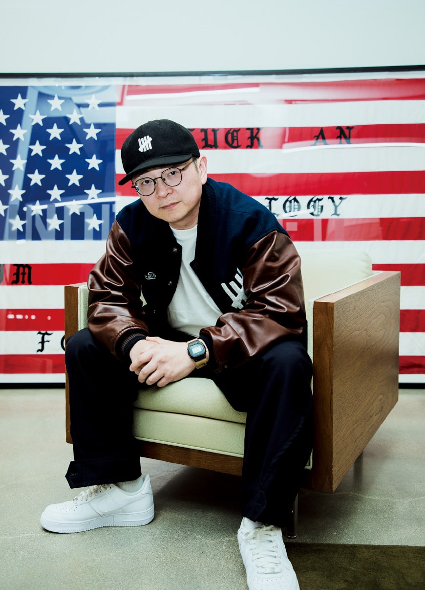 Eric Cheng zit in een fauteuil voor een ingelijste Amerikaanse vlag met daarop citaten