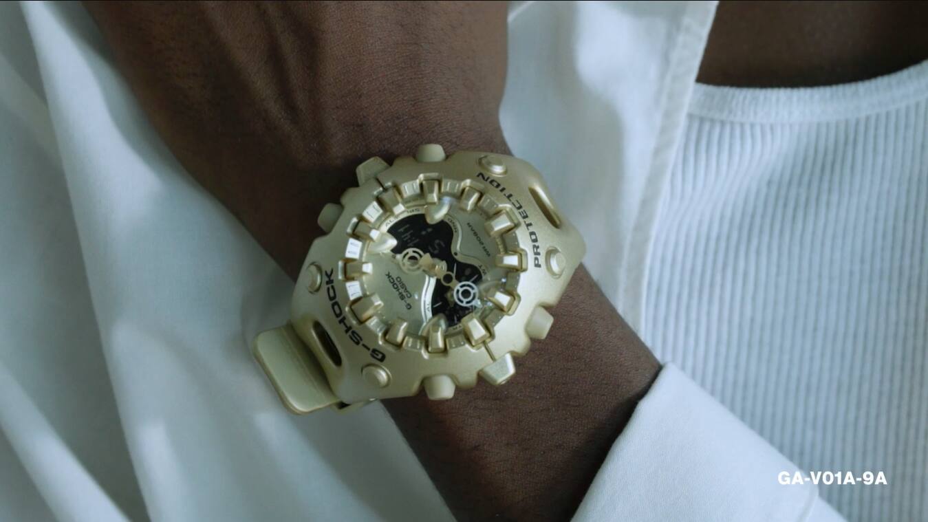 Pop-Up van een Youtube-video van een model dat de gouden G-Shock GA-V01 draagt in een witte studio.