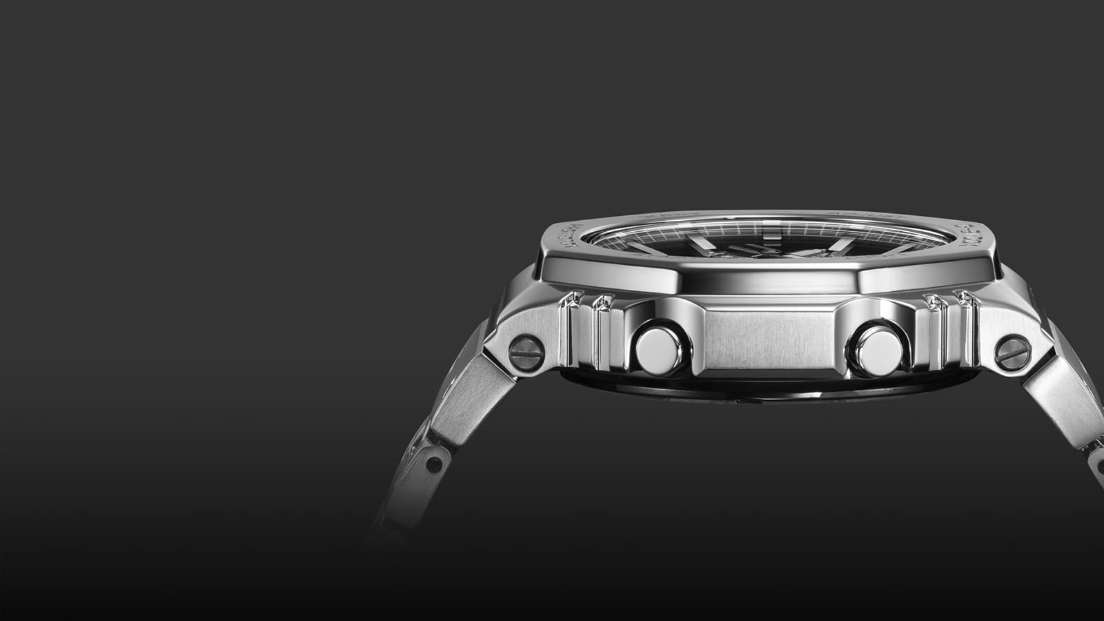 Zijaanzicht van de platte, zilveren kast van het Casio G-Shock GM-B2100D polshorloge met de knoppen en schroeven