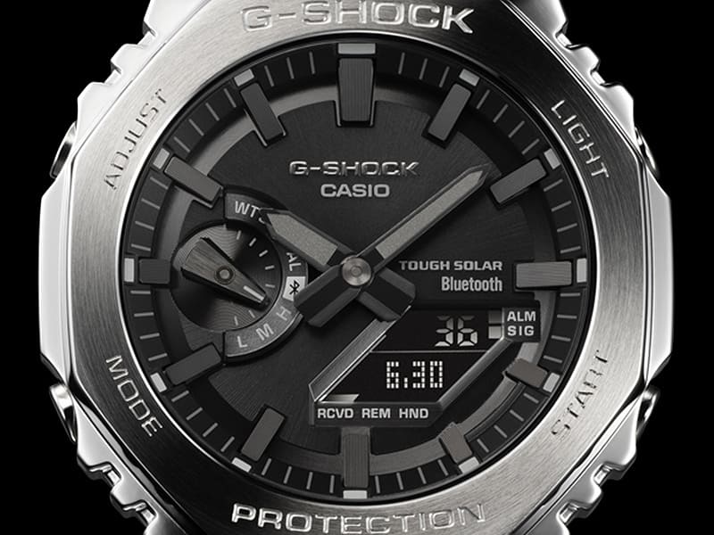 Close-up van de zwarte wijzerplaat van het Casio G-Shock GM-B2100 polshorloge met zilverkleurige roestvrijstalen kast