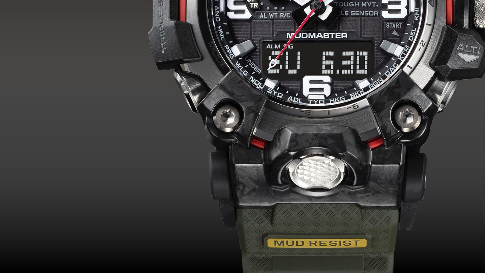 Close-up van het punt waar de kast en de armband samenkomen, met zicht op de onderste helft van de wijzerplaat en de “Mud Resist” belettering op de armband