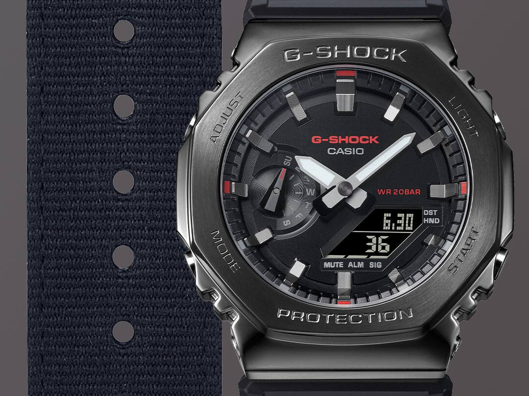 Grande plano da bracelete em tecido preto, do mostrador preto e da caixa preta em aço inoxidável do relógio de pulso híbrido Casio G-Shock GM-2100CB-1A
