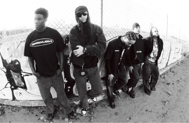 Uma foto a preto e branco da equipa da Babylon LA em frente a uma cerca de arame