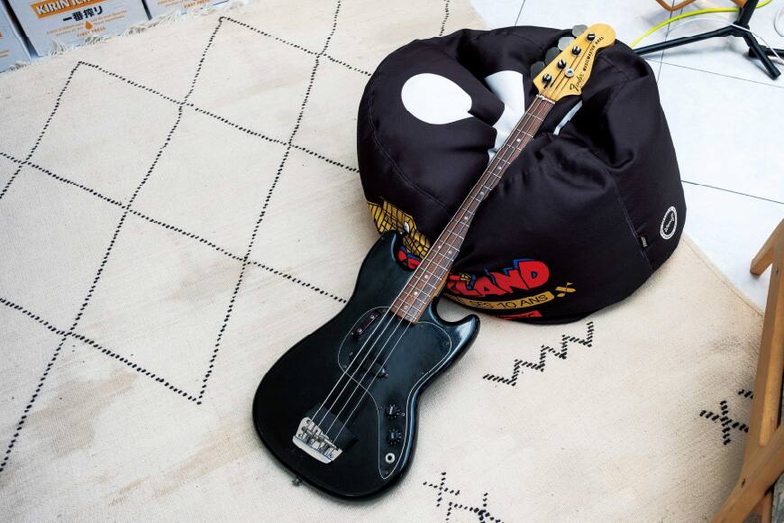 Uma guitarra preta colocada no chão.