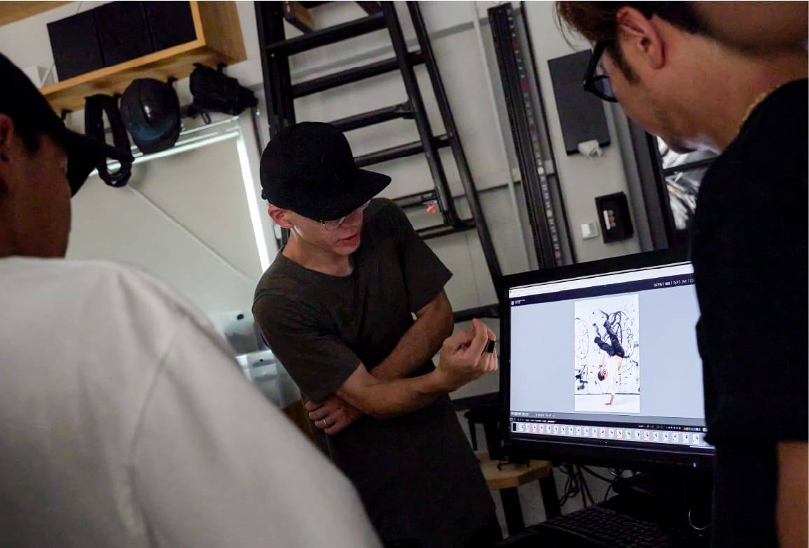 Três homens em frente a um ecrã de computador num estúdio.