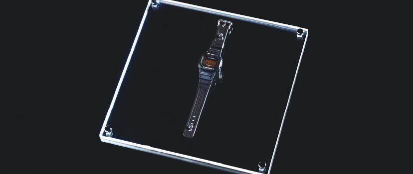 Um relógio de pulso G-SHOCK DW-5600 está deitado sobre um disco de vidro.
