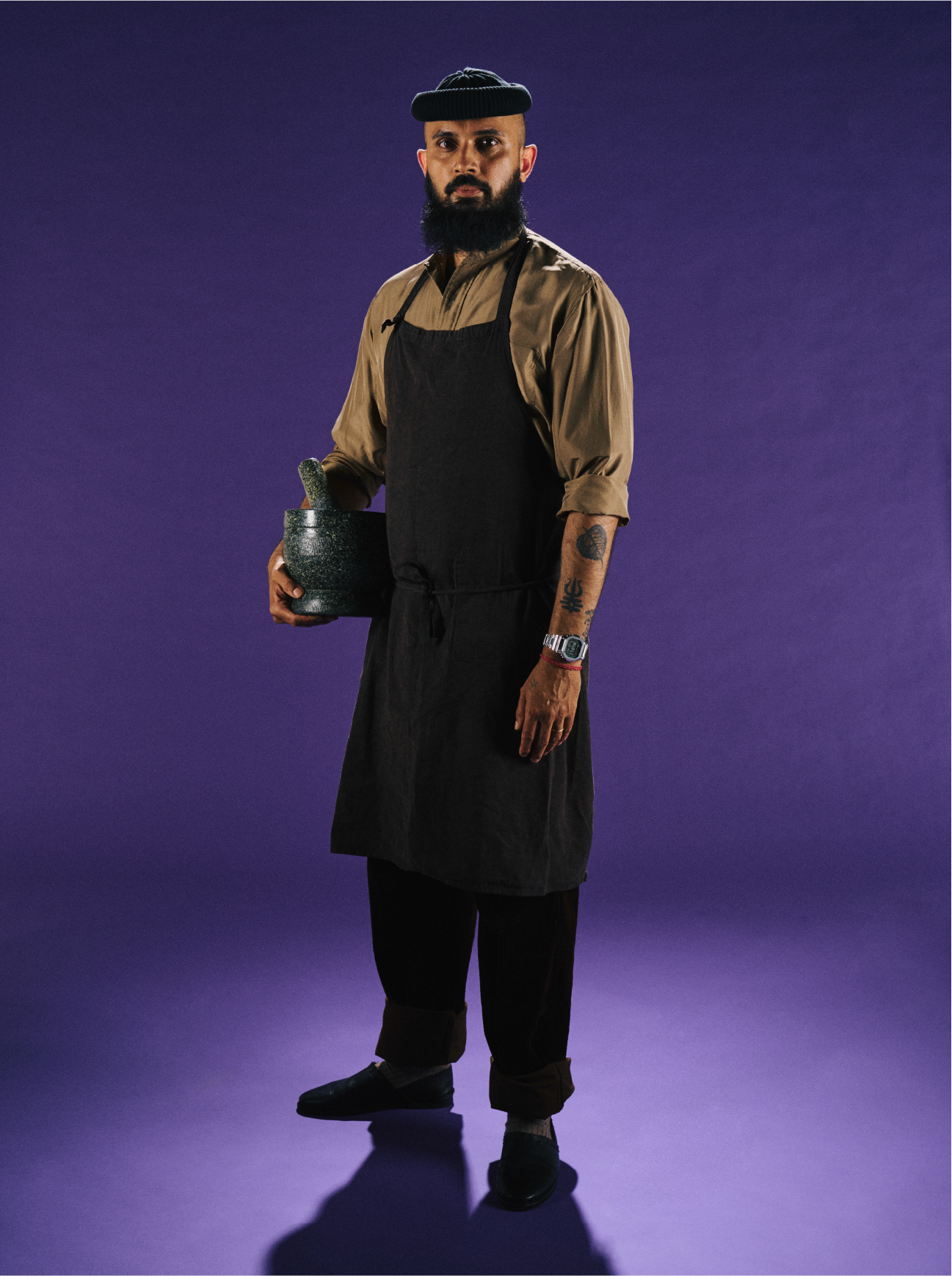 O chefe de cozinha Kanchan Adhikari carrega um almofariz na mão direita, no braço esquerdo usa o relógio de pulso fino G-SHOCK GMW-B5000D-3 com design profissional