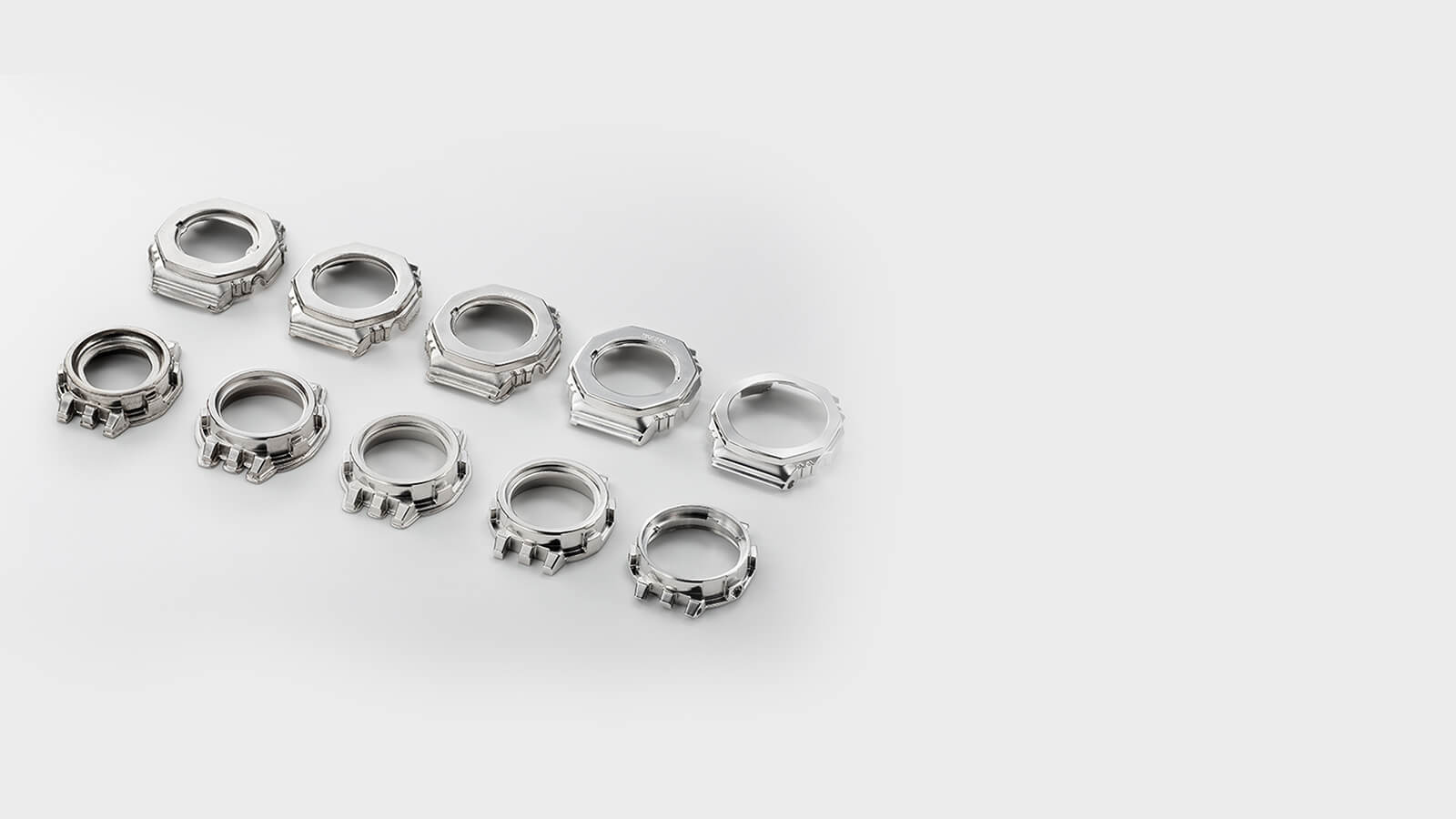   Dez lunetas prateadas em várias fases de produção - desde a luneta em branco até à luneta acabada