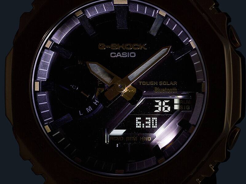 Um relógio de pulso Casio GM-B2100 no escuro com mostrador iluminado