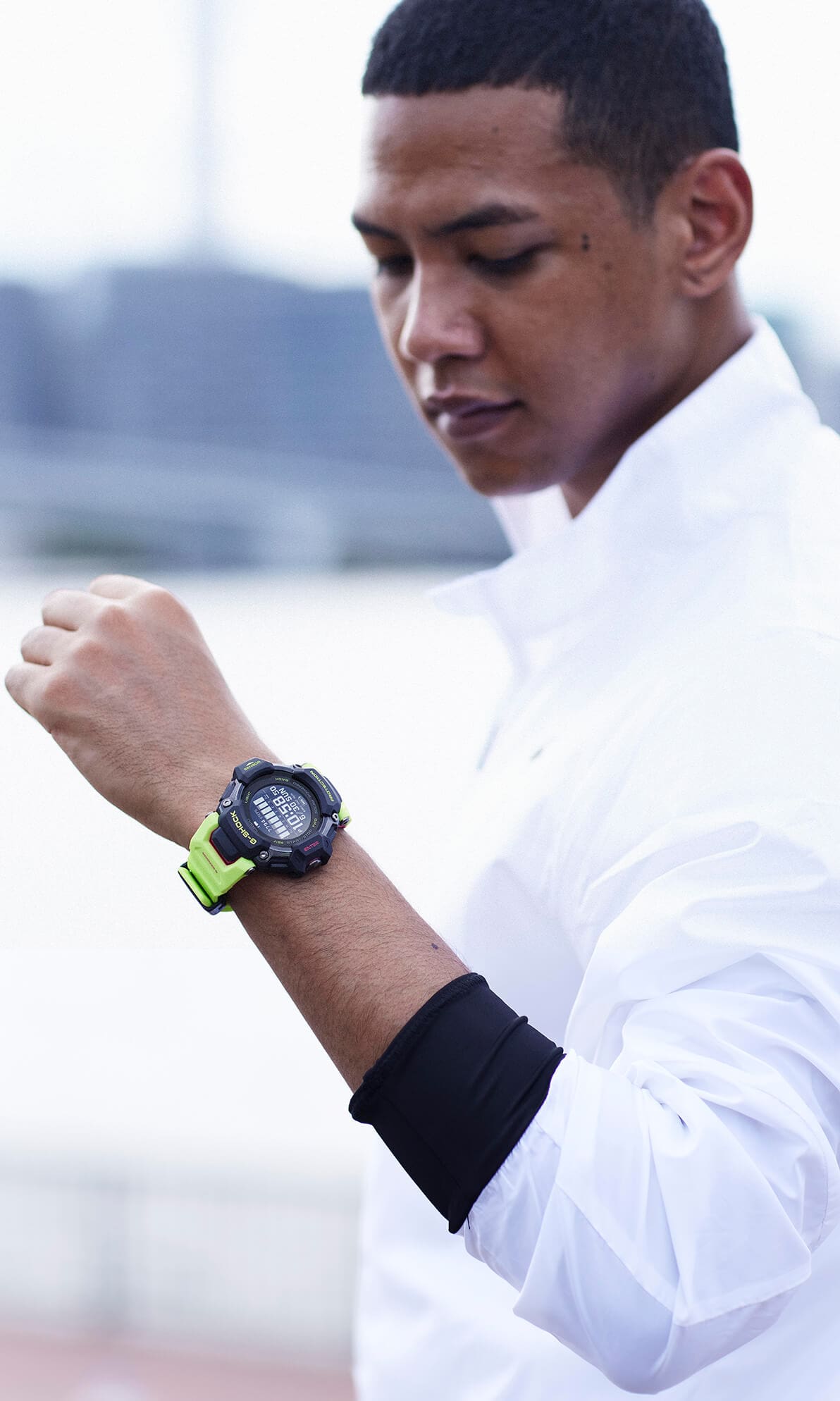 O relógio de pulso Casio G-Squad GBD-H2000-1A9 no pulso de um homem com uma camisa branca