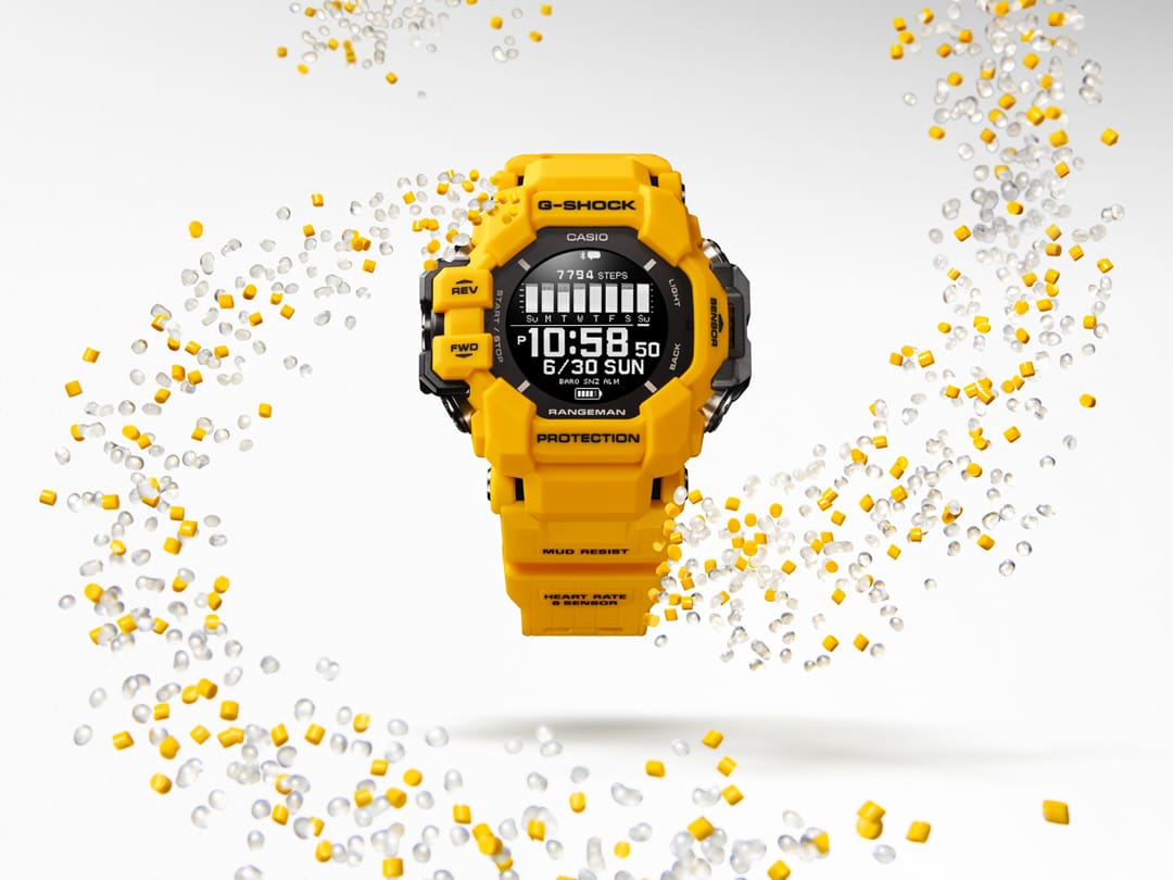O relógio Casio G-Shock GPR-H1000-9 amarelo para actividades ao ar livre, rodeado por remoinhos de granulado de resina transparente e amarela