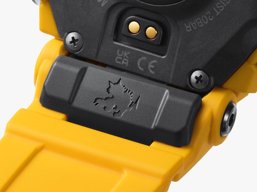 Grande plano do local onde a bracelete amarela e a caixa preta se encontram com uma vista da gravação do gato selvagem Rangeman na parte de trás do relógio