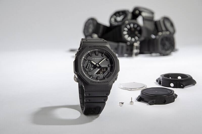 Um relógio de senhora Casio G-Shock preto em frente às peças individuais que o compõem
