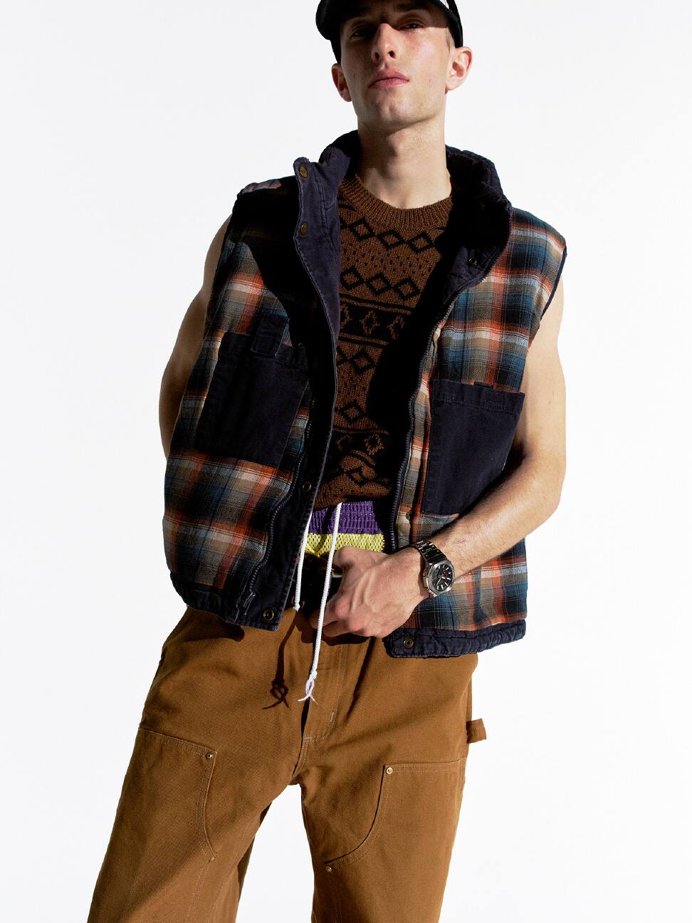 一個人身穿格仔背心戴著黑色 G-SHOCK，擺出悠閒站立姿勢。